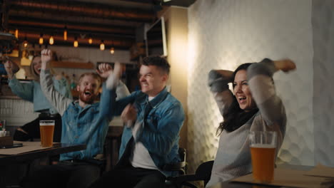Friends-and-fans-rejoice-together-emotionally-watching-football-on-TV-in-a-bar-and-celebrating-the-victory-of-their-team-after-scoring-a-goal.-Watch-basketball-hockey.-The-scored-puck.-Fans-in-the-pub